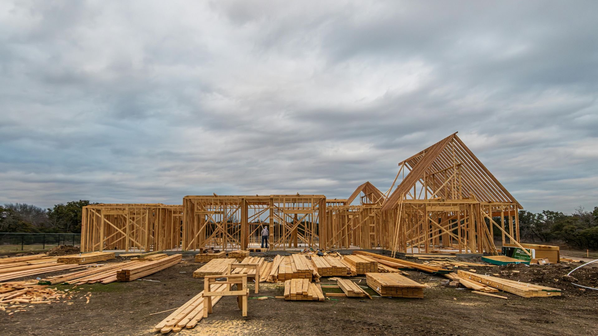 Wooden house frames under construction on a cloudy day