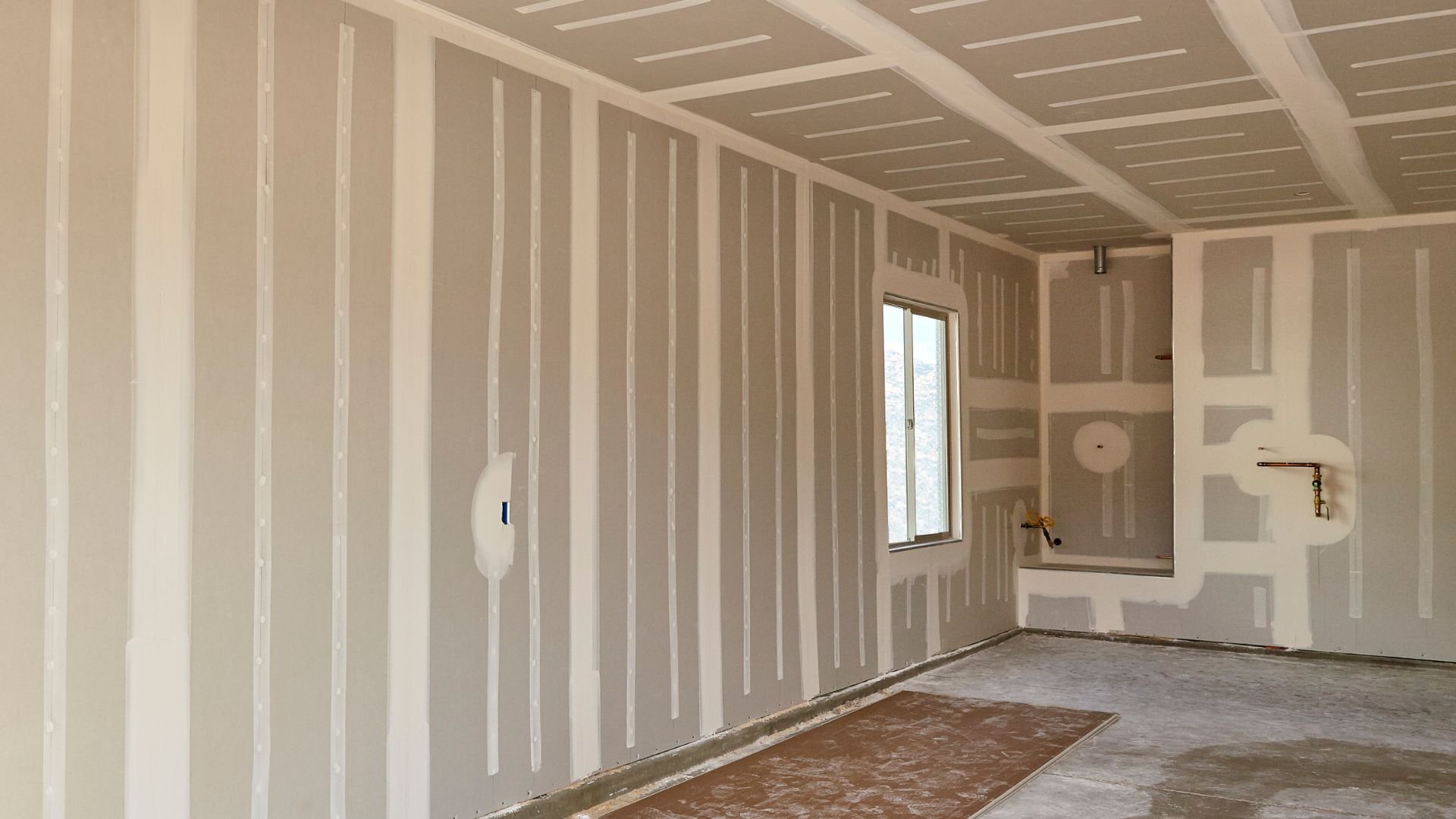 Interior room with drywall, window, and exposed construction in progress