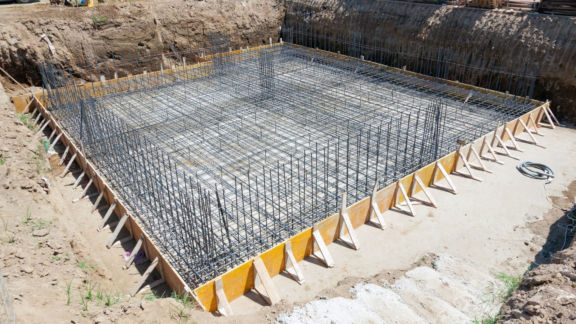 Reinforced steel rebar grid prepared for concrete foundation at construction site